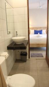 a bathroom with a sink and a toilet and a bed at Wisna House in Sanur +41 photos