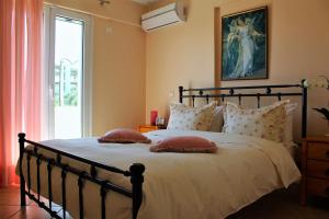 a bedroom with a large bed with pillows and a window at Helen's Sounio Apartments in Sounio