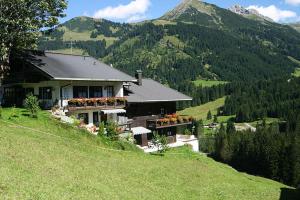 ein Haus auf einem Hügel mit einem Berg in der Unterkunft Villa Valluga in Mittelberg