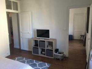 a living room with a tv on a stand at Appartements Plantagenet - Le 27 in Le Mans