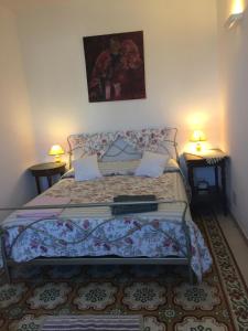 a bed in a bedroom with two lamps on tables at Casa Verde Sardinia in Cuglieri