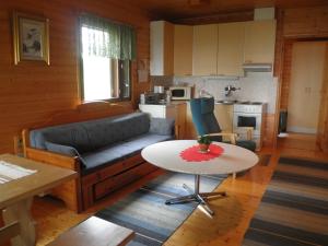 a living room with a couch and a table at Koskelon Lomamökit in Rääkkylä
