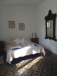 a bedroom with a bed and a mirror on the wall at Casa Verde Sardinia in Cuglieri