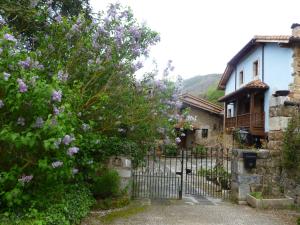 una puerta frente a una casa con flores púrpuras en La Posada de Viñón - Casa Reda, en Viñón