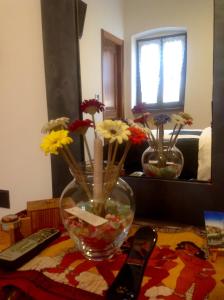 een vaas met bloemen erin op een tafel bij Guest House Santiago in Arco