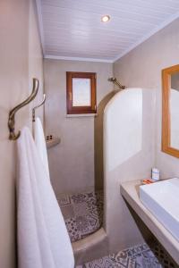 bagno con doccia, lavandino e asciugamani di Lardas Luxury Country House a Kíssamos