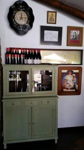 a green cabinet with a clock and bottles of wine at Mercadoiro in Laje +38 photos