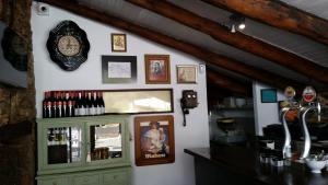 a wall with a clock and a shelf with wine bottles at Mercadoiro in Laje