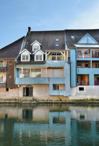 a building next to a body of water at Appartement Le Chalet in Ornans