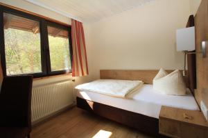 a bedroom with a bed and a window at Waldhotel Albachmühle mit Albacher Stuben in Wasserliesch +43 photos