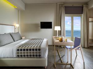 1 dormitorio con cama, escritorio y mesa con escritorio en Irida Hotel en La Canea