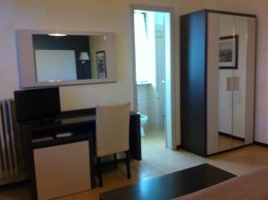 een woonkamer met een bureau en een spiegel bij Hotel La Palma in Lido di Camaiore