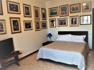 a bedroom with a bed and framed pictures on the wall at Superpanoramico in Cagliari