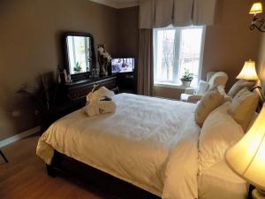 a bedroom with a large white bed and a mirror at L'Oasis de l'Île in Saint-Eustache