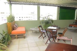 um pátio com uma mesa e cadeiras, uma mesa e uma espreguiçadeira em Le House Hostel no Rio de Janeiro