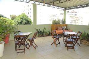 a patio with tables and chairs and plants at Le House Hostel in Rio de Janeiro