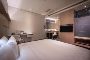 a hotel room with a large bed and a kitchen at Taipei 101 SPARKLE Hotel in Taipei