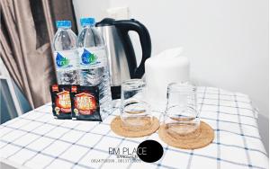 een tafel met twee glazen en een kruik water bij PM Place in Bangsaen
