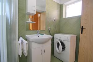 ein Badezimmer mit Waschbecken und Waschmaschine in der Unterkunft Holiday House Palma in Dobrinj