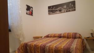 een slaapkamer met een bed en twee foto's aan de muur bij Al Fontanone in Cecchina