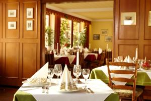 uma sala de jantar com mesas com toalhas de mesa verdes em Hotel Winzerverein em Zeltingen-Rachtig