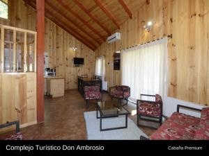 sala de estar con sofá, sillas y mesa en Cabanas Turismo Don Ambrosio en El Manzano