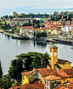 a city with a river and a clock tower at Residenza Christian in Gravedona