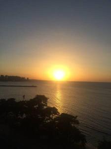 una puesta de sol sobre un gran cuerpo de agua en Vila Costeira Flat Apto Particular, en Fortaleza