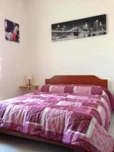 een slaapkamer met een bed met een paarse deken bij Al Fontanone in Cecchina