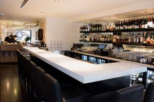a bar with a long white counter and black chairs at Inn at the Market in Seattle