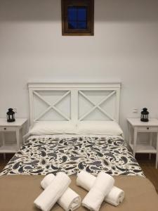 una camera da letto con un letto e due asciugamani sul pavimento di Apartamentos Catedral Escalinata a Toledo
