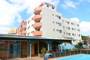 a hotel with a pool in front of it at Hotel Nossa Casa in Ijuí