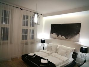 a bedroom with a white bed with a black suitcase on it at Black&White Apartment- Wierzbowa 5 in Poznań