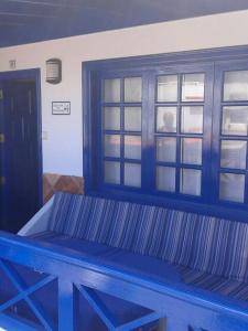 eine blaue Bank in einem Zimmer mit Fenster in der Unterkunft El Pescador in Famara