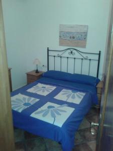 Schlafzimmer mit einem Bett mit einer blauen und weißen Bettdecke in der Unterkunft El Pescador in Famara