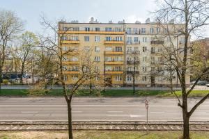 ワルシャワにあるP&O Apartments Waszyngtonaの黄色い建物前の空き道