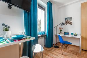 salon z niebieskimi zasłonami, stołem i krzesłami w obiekcie P&O Apartments Waszyngtona w Warszawie +18 zdjęć