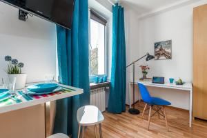 sala de estar con cortinas azules, mesa y sillas en P&O Apartments Waszyngtona, en Varsovia