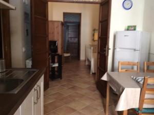 a kitchen with a white refrigerator and a table and a kitchen at B&B Del Corso in Mazara del Vallo