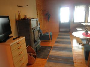 a living room with a television and a kitchen with a table at Koskelon Lomamökit in Rääkkylä