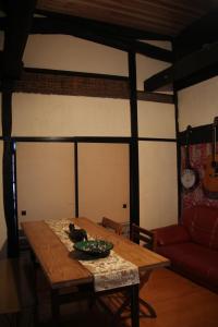 a living room with a table and a red couch at Madarao Farm in Nakano
