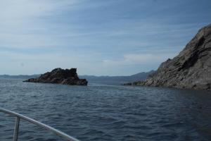 a boat in the water next to some rocks at Hostal Juventus in Portbou