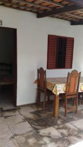 - une table et des chaises dans une chambre avec fenêtre dans l'établissement Suítes São Judas, à Pirenópolis