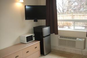 a kitchen with a refrigerator and a tv and a window at Trailside Inn in Lloydminster