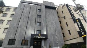 a building with a hotel sign in front of it at Hotel Tong Yeondong Jeju in Jeju