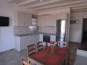 アンティパロス・タウンにあるOrange Apartmentのキッチン(テーブル、椅子、冷蔵庫付)