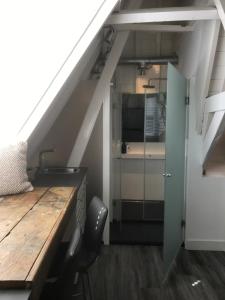 a kitchen with a wooden table and a kitchen under a stairs at NR22 Leiden in Leiden