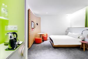 
a room with a bed, a desk, and a mirror at MU Hotel in Ipoh
