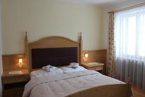 a bedroom with a large bed with two pillows on it at Berggasthof Pension Pfitscher in Unsere Liebe Frau im Walde