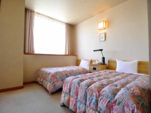 a hotel room with two beds and a window at Hotel King in Izumi